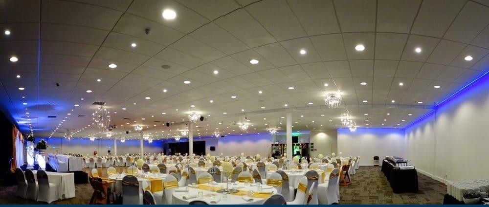 Manukau Event Centre set for a gala dinner, with blue wall uplighting